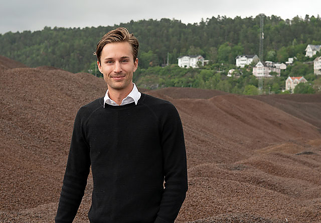 Bjørn Halvard Knappskog foran et berg av pellets. 